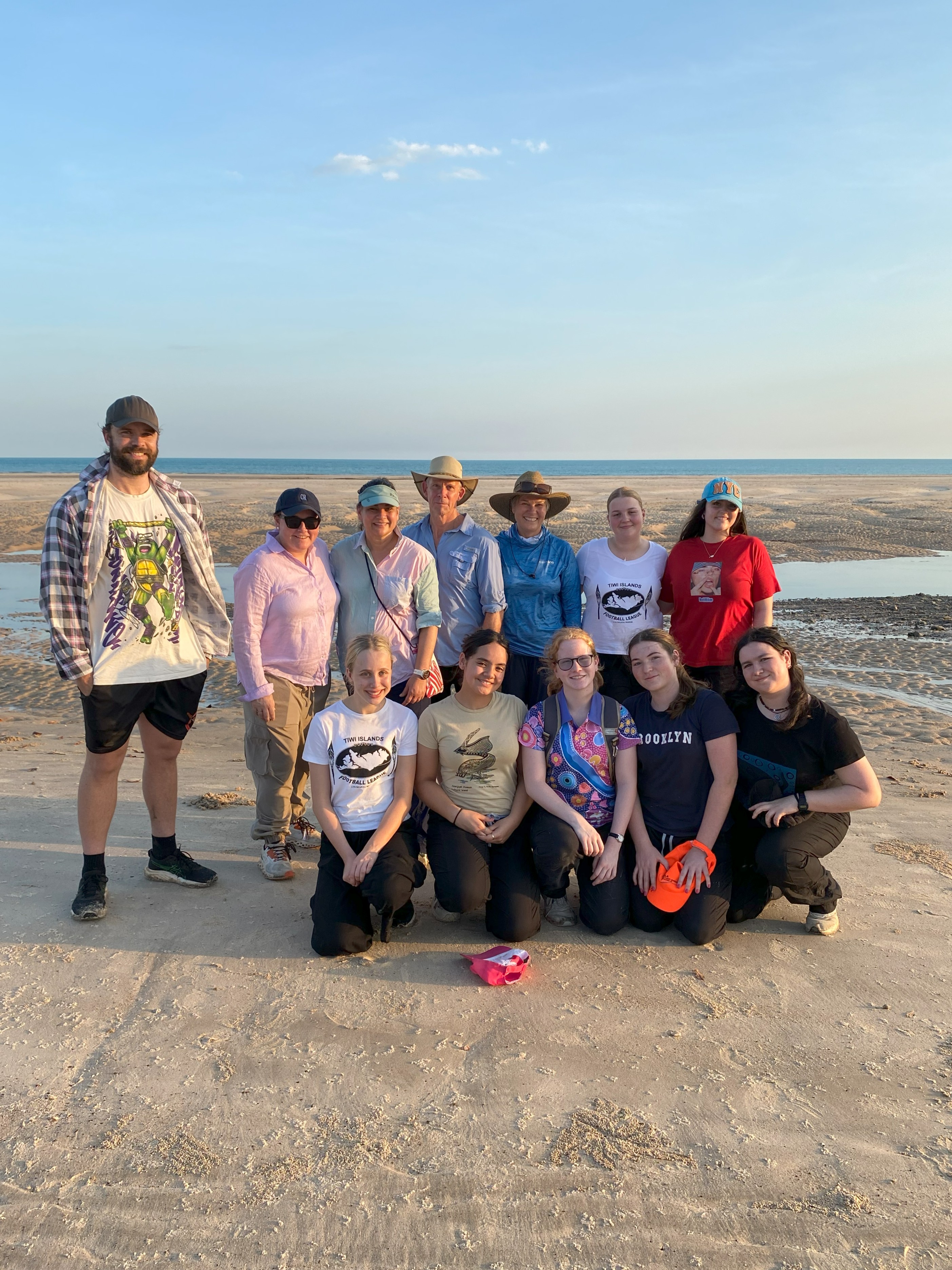 Group of students and teachers standing together on a tidal flats landscape during an outdoor learning experience