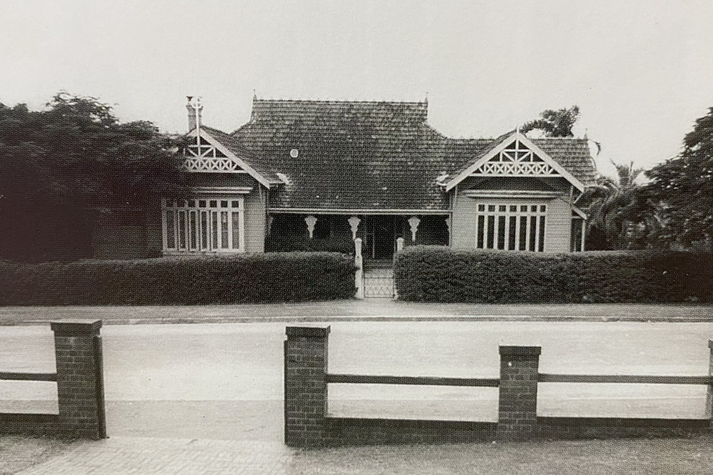 Historic black and white photo of an early school building viewed from across the street