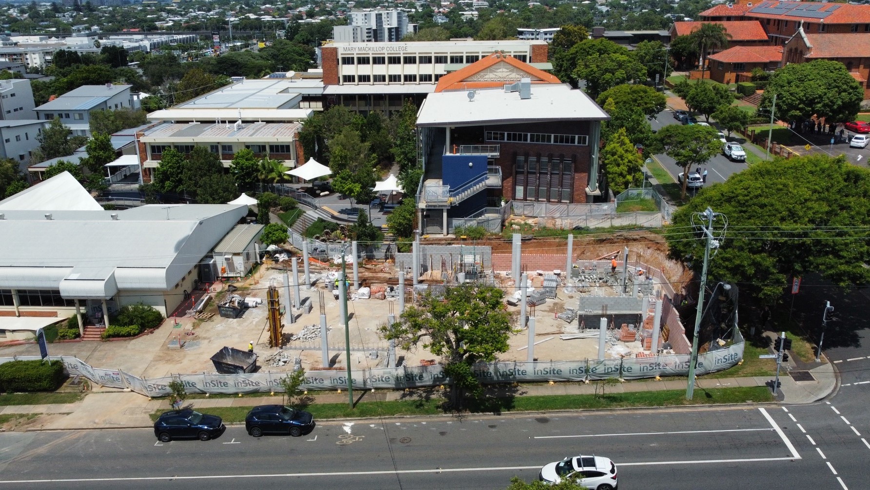 Aerial view of a school campus showing construction works and surrounding buildings